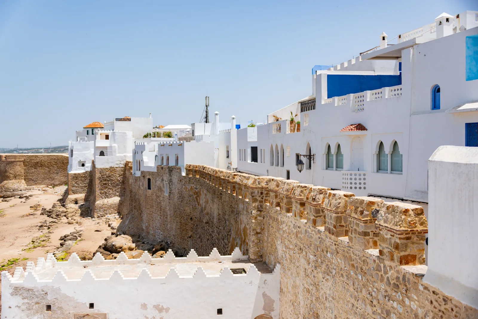 The whitewashed houses of Asilah's old medina above the Portuguese sea ramparts, seen from Borj Krikia, the destination of this private day trip from Tangier
