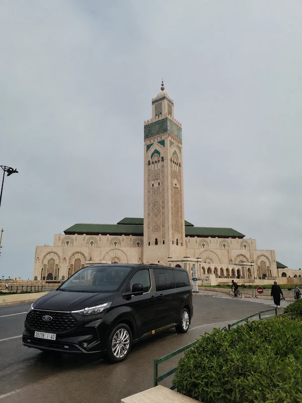 Black transfer van parked in front of the Hassan II Mosque in Casablanca at the end of the drive